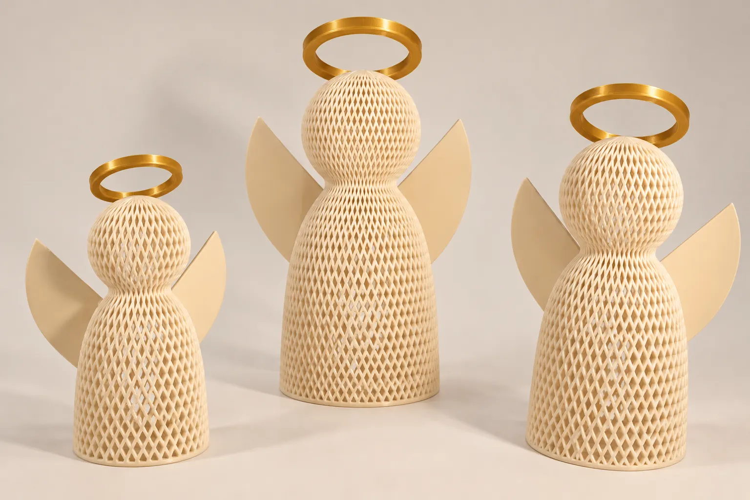 Três anjos decorativos impressos em 3D, em tamanhos diferentes, com corpo em trama vazada creme e auréolas douradas