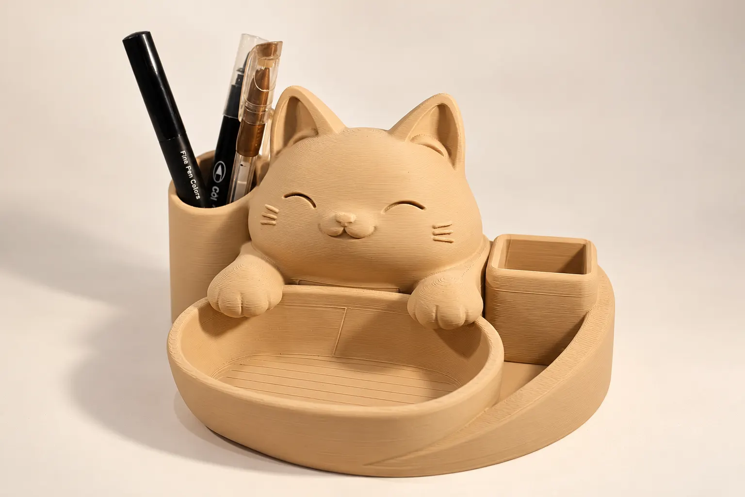 Organizador de mesa em forma de gato sorridente com canetas no porta-canetas