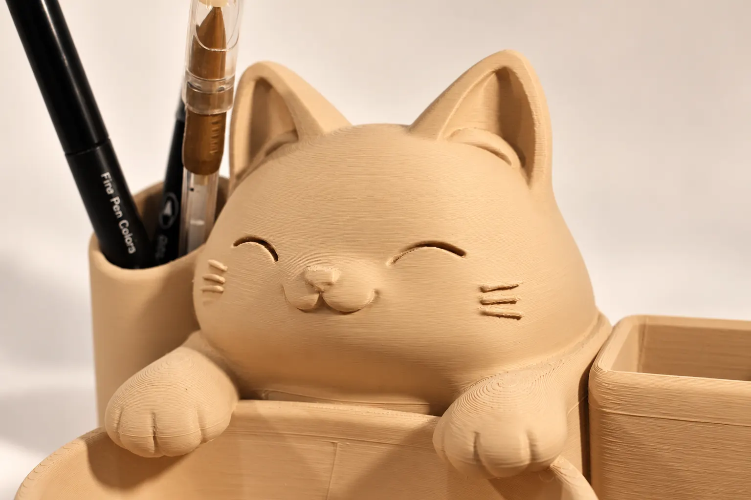 Detalhe do rosto do gato no organizador de mesa com bigodes e patinhas em relevo